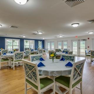 A bright and spacious dining room with neatly arranged tables and chairs.