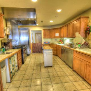 A spacious kitchen featuring wooden cabinets and modern appliances, ideal for cooking and entertaining.