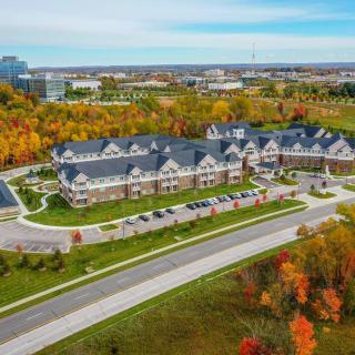 An aerial view of a large building surrounded by colorful autumn foliage.
