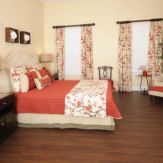 A cozy bedroom with floral decor and warm colors.