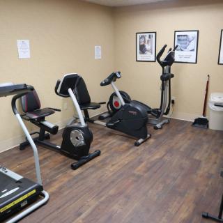 A small gym with various exercise equipment, including treadmills and stationary bikes.