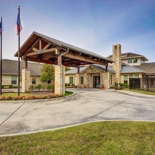 A modern building with an entrance canopy and surrounding landscaping.