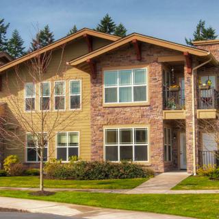 A two-story suburban apartment building with a brick exterior and well-maintained landscaping.