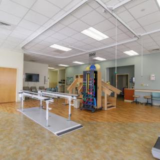 A spacious physical therapy room equipped with exercise apparatus for rehabilitation.
