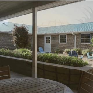 A cozy patio overlooking a courtyard with lush greenery and outdoor seating.