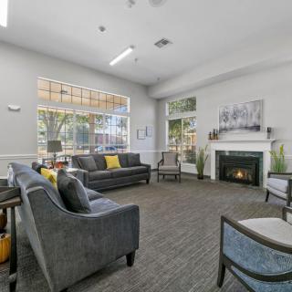 A modern living room featuring comfortable sofas, a fireplace, and large windows providing ample natural light.