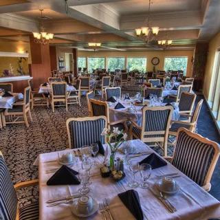 An elegantly set restaurant dining area with neatly arranged tables and chairs.