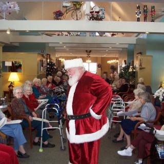 Santa Claus visits a nursing home during a festive holiday gathering.