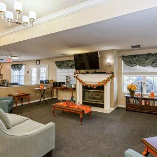 A cozy living room featuring a fireplace, wall-mounted television, and comfortable seating.