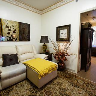 A cozy living room with a sofa, decorative artwork, and a warm ambiance.