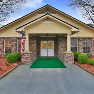 A well-maintained building entrance with a symmetrical design and landscaping.