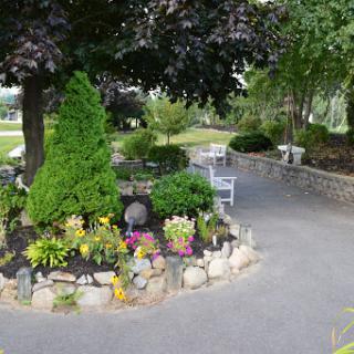 A serene garden pathway surrounded by lush greenery and vibrant flowers.