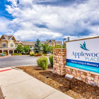 Entrance to Applewood Place with a sign and landscaped surroundings.