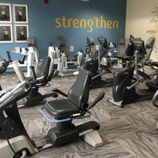 A gym setting with several exercise bikes arranged in rows, ready for use.