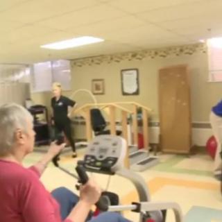 A person engages in physical therapy using exercise equipment in a rehabilitation center.