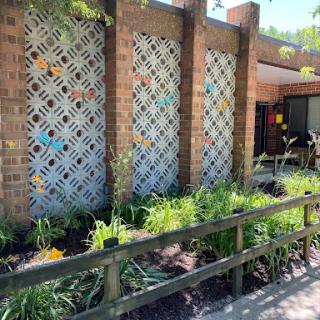 A vibrant garden area featuring decorative lattice walls and colorful flowers.