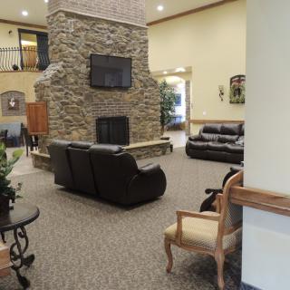 Spacious lobby with a central stone fireplace and comfortable seating.