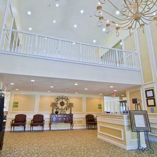 Spacious and well-lit lobby with a prominent chandelier and reception desk.