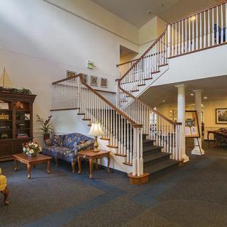 A spacious living area featuring a staircase, comfortable seating, and elegant decor.