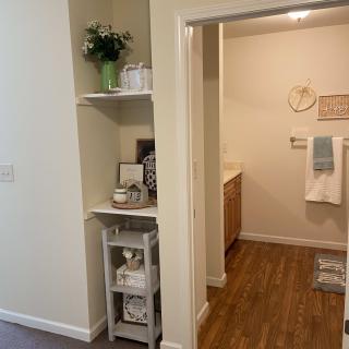 A well-organized bathroom with neatly arranged shelves and decor.