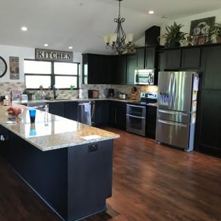 Spacious modern kitchen with dark cabinets and a large island.