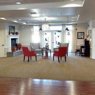 A cozy lobby area with red chairs and a fireplace.