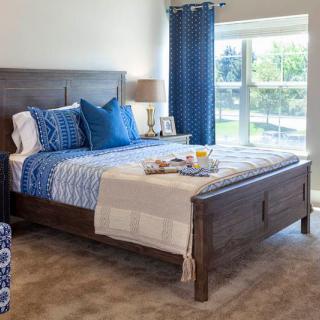 A cozy bedroom with blue accents and natural light.