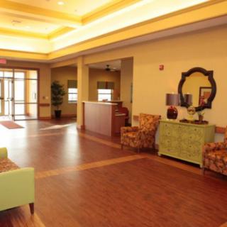 A spacious and warmly lit lobby with comfortable seating and a reception desk.