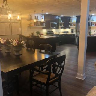 Modern kitchen and dining area with dark wood furniture and dim lighting.