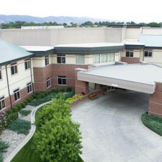 A modern building with landscaped greenery and a covered entrance.