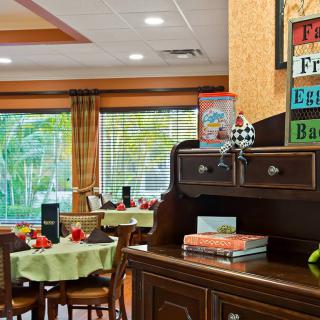 A cozy dining area with neatly arranged tables and a decorative sign in the foreground.