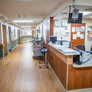 An empty hospital hallway with a nurse station.