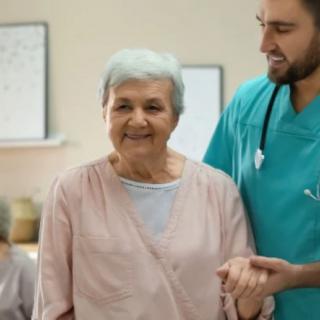 A nurse assists an elderly woman, offering support and care.