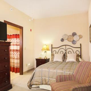 Cozy bedroom with a bed, dresser, and decorative elements.