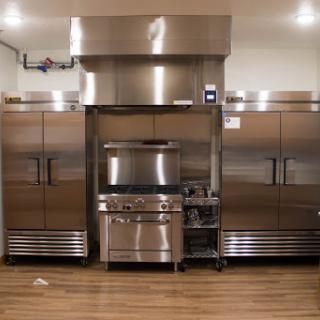 A modern commercial kitchen featuring stainless steel appliances and cooking equipment.