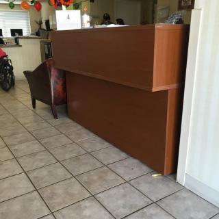 A reception area with a wooden desk and tiled floor.