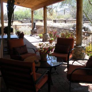 A cozy patio with outdoor furniture and a view of the garden.