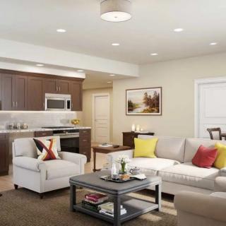A modern living room with an open concept design featuring a sofa, coffee table, and adjacent kitchen.