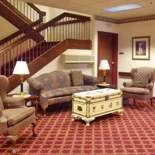 A cozy lobby area with classic furniture and a patterned carpet.