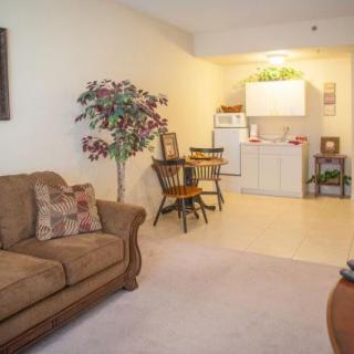 Cozy living area with a sofa and dining space, overlooking a compact kitchen.
