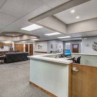Modern office reception area with desk and seating.