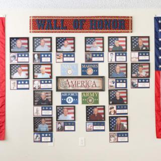 A Wall of Honor display featuring photographs and patriotic decor, dedicated to honoring military service.