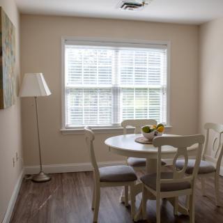 A cozy dining area with a round table and chairs next to a window.