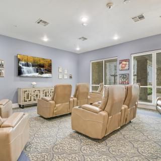 A modern living room with comfortable armchairs and a television.