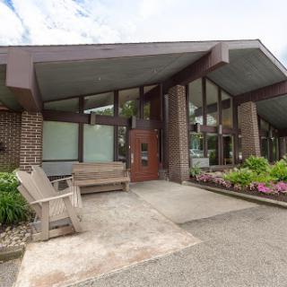 A modern architectural entrance with outdoor seating and landscaped flowers.