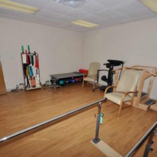 A therapy room equipped with exercise tools and seating for rehabilitation exercises.
