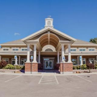 A large building with a prominent entrance featuring columns, viewed on a clear day.
