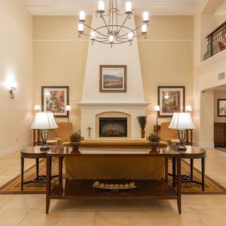 A beautifully designed living room featuring a fireplace, elegant chandelier, and tasteful artwork.