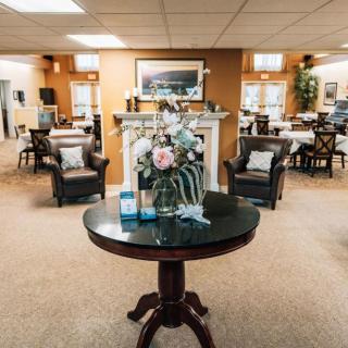 A cozy lobby area with elegant furnishings and a centerpiece table adorned with flowers.