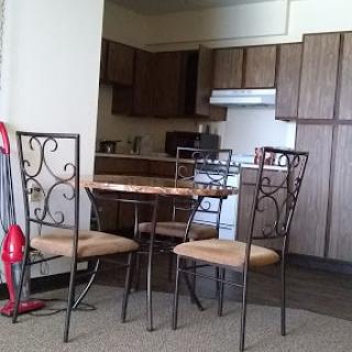 A cozy kitchen setup featuring a quaint dining table and chairs.